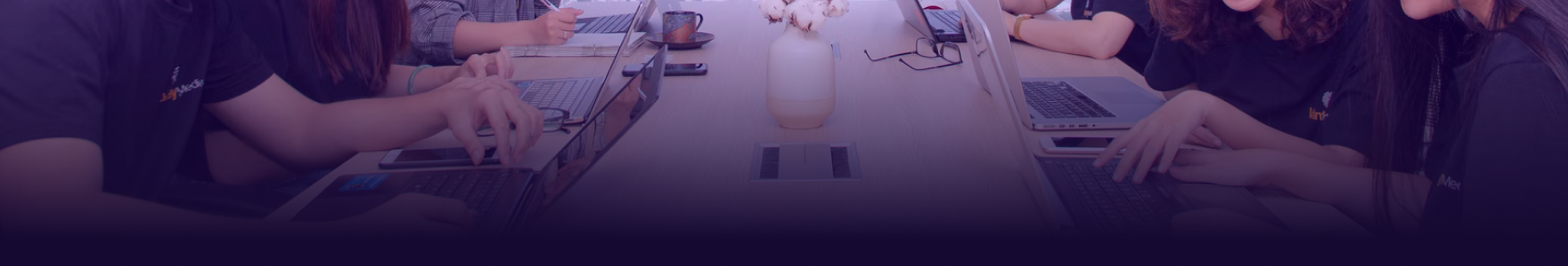 Group of students sitting on laptops programming.